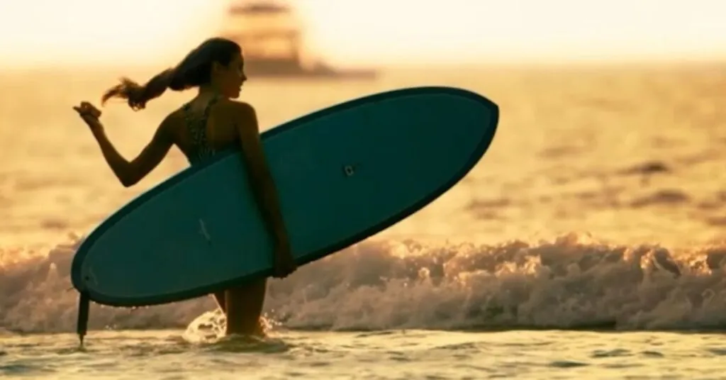 Woman holding a surfboard at sunset on a Costa Rica beach
